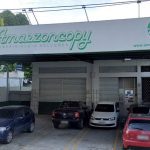 Fachada da Amazzoncopy, gráfica com carros estacionados.