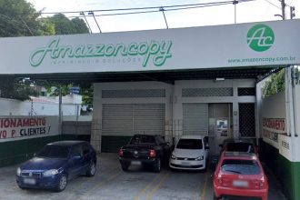 Fachada da Amazzoncopy, gráfica com carros estacionados.