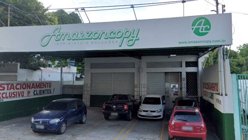 Fachada da Amazzoncopy, gráfica com carros estacionados.