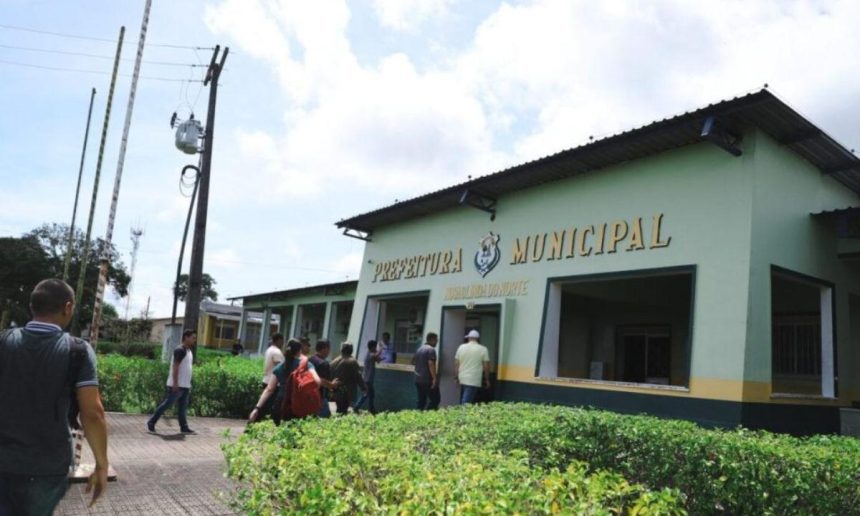 Fachada da Prefeitura Municipal de Nova Olinda do Norte, com pessoas entrando e saindo.