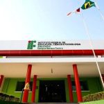 Fachada do Instituto Federal de Educação, Ciência e Tecnologia do Amazonas (IFAM) - Campus Manaus Centro, com bandeiras e céu azul.