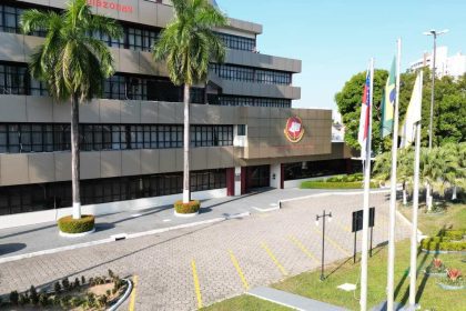 Fachada do Ministério Público, com prédios e palmeiras.