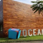 Fachada do Samsung Ocean com design moderno em madeira, com logo da Samsung e escultura.