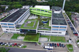 Fachada moderna da Faculdade Matias Machline com área verde e estacionamento.