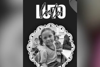 Foto em preto e branco de menina sorrindo com a palavra Luto no topo, em homenagem.