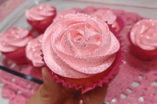 Cupcakes decorados com glacê rosa em formato de rosa e glitter.
