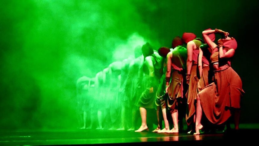Grupo de bailarinos em um palco com iluminação verde, parte da programação do II Arte Ocupa no Teatro ICBEU.