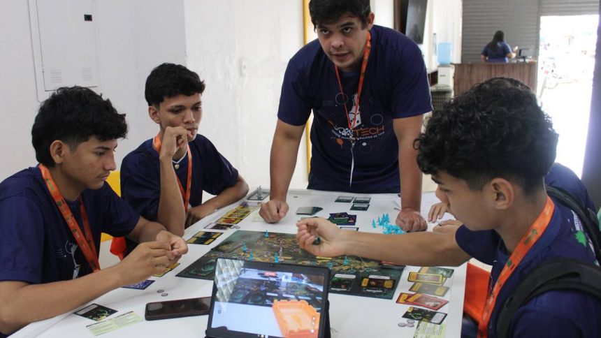 Grupo de jovens jogando jogo de tabuleiro durante o torneio Jogatech em Tefé, Amazonas.