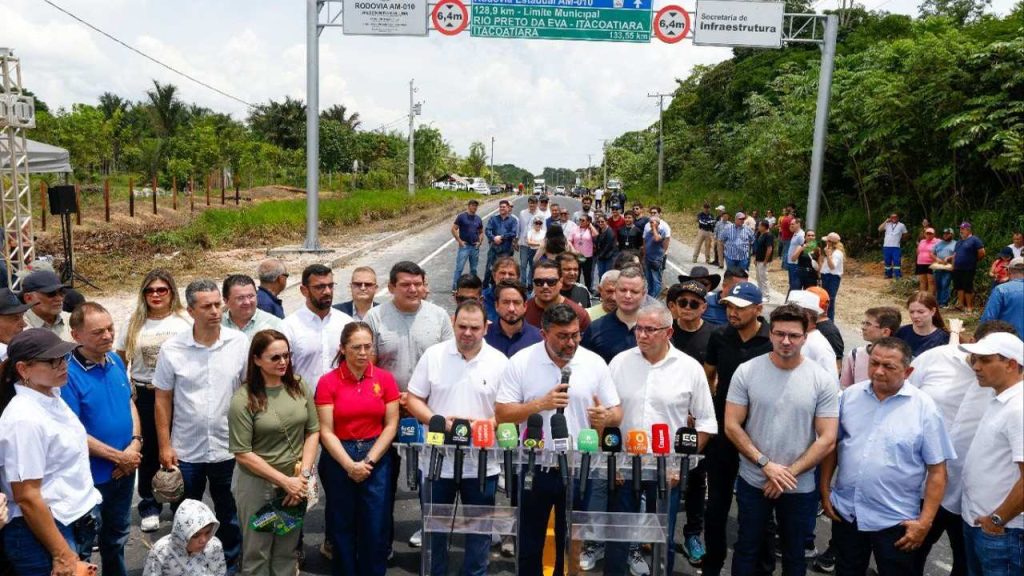 Grupo de pessoas reunidas em evento com autoridades e o Governador Wilson Lima em frente a placa de rodovia AM-010.