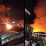Incêndio destrói casa à noite, com fumaça e chamas intensas.