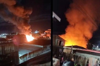 Incêndio destrói casa à noite, com fumaça e chamas intensas.