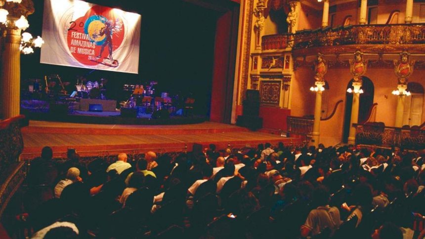 Interior de teatro com palco e plateia lotada durante o Festival Amazonas de Música.