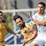 Jogadores de futebol em ação durante uma partida.