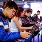 Jovens participam da Maratona de Vagas do Ciee, concentrados em dispositivos eletrônicos.