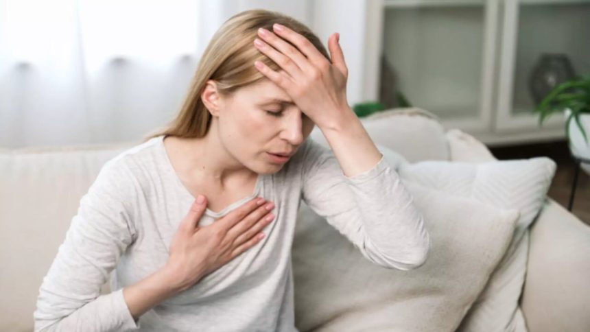 Mulher com a mão na testa e no peito, demonstrando ansiedade.