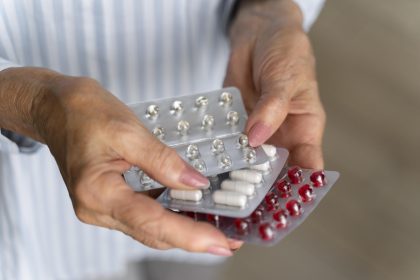 Mãos segurando cartelas de comprimidos