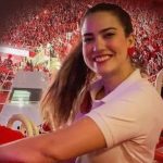 Mulher sorrindo em evento, em homenagem à irmã do amo do Boi Garantido, falecida em São Paulo.