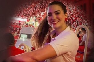 Mulher sorrindo em evento, em homenagem à irmã do amo do Boi Garantido, falecida em São Paulo.