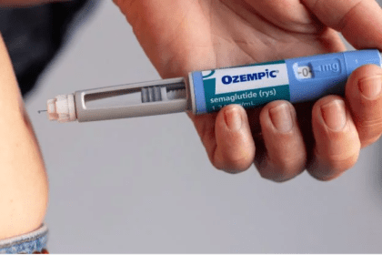 Injeção de Ozempic sendo aplicada no abdômen. Caneta injetora e pele visíveis.