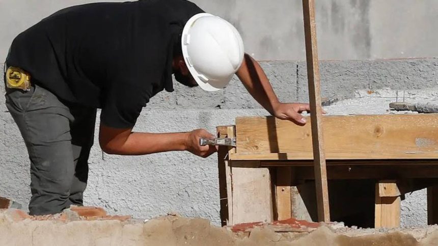 Pedreiro trabalhando em uma obra de construção com ferramentas e madeiramento