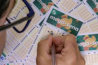 Pessoa preenchendo um bilhete da Mega-Sena com uma caneta.