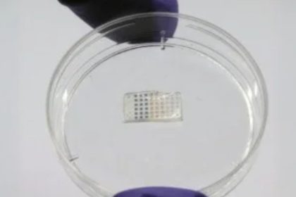 Adesivo cardíaco com estrutura retangular contendo pequenos quadrados coloridos, um dispositivo médico.