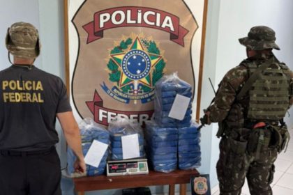 Polícia Federal apreende drogas durante operação no Amazonas. Policiais e drogas apreendidas em primeiro plano, símbolo da PF ao fundo.