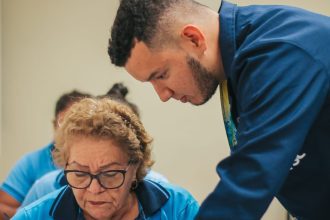 Professor auxilia aluna durante aula da EJA (Educação de Jovens e Adultos) no Sesc Amazonas.