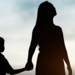 Silhueta de mãe e filha de mãos dadas, com céu ao fundo.