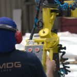 Técnico da MDG Filmes operando equipamento em fábrica