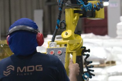 Técnico da MDG Filmes operando equipamento em fábrica