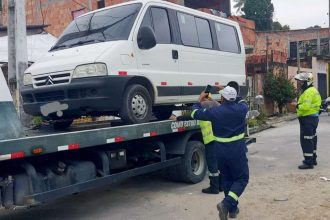Veículo escolar branco apreendido em guincho por transporte irregular de crianças em Manaus