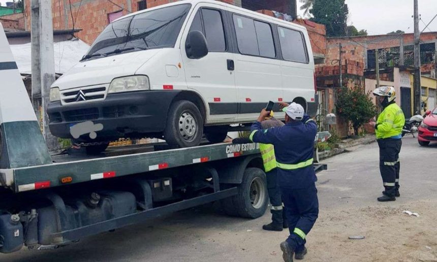 Veículo escolar branco apreendido em guincho por transporte irregular de crianças em Manaus