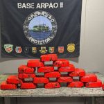 Apresentação de apreensão de drogas pela Polícia Civil do Amazonas. Blocos vermelhos empilhados sobre uma mesa.