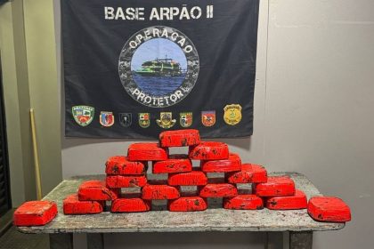 Apresentação de apreensão de drogas pela Polícia Civil do Amazonas. Blocos vermelhos empilhados sobre uma mesa.