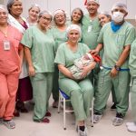 Equipe médica celebra nascimento de bebê usando gorro de Papai Noel.