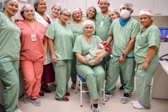 Equipe médica celebra nascimento de bebê usando gorro de Papai Noel.