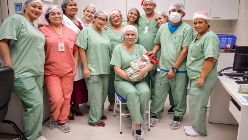 Equipe médica celebra nascimento de bebê usando gorro de Papai Noel.