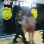 Polícia Civil conduz suspeitos para dentro da delegacia. Insígnia da polícia visível.