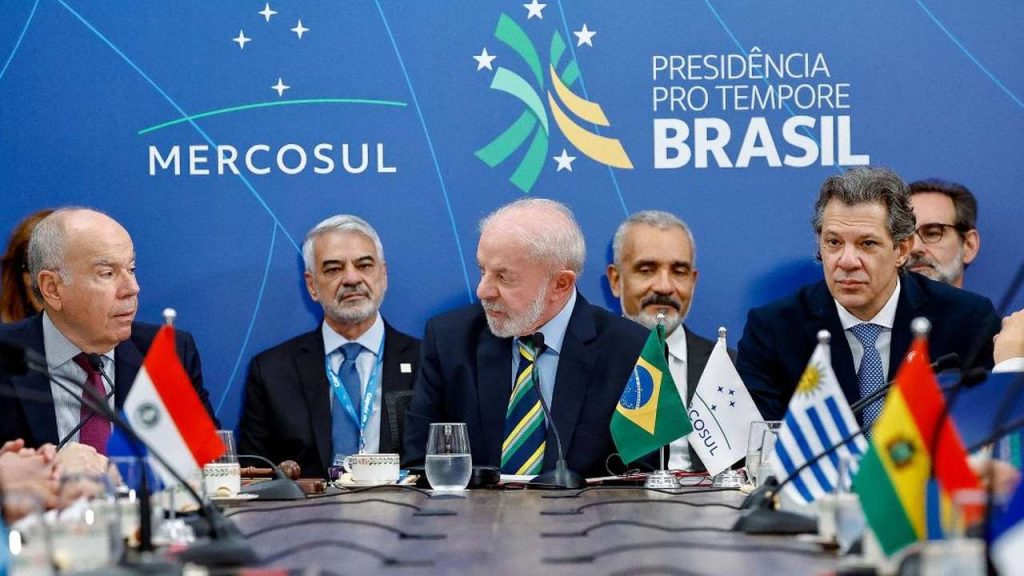 Reunião do MERCOSUL com líderes políticos e bandeiras nacionais sobre a mesa