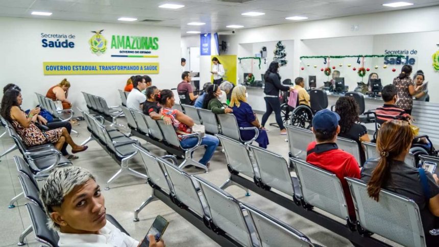 Sala de espera com pessoas sentadas em cadeiras de metal, aguardando atendimento em um centro de saúde.