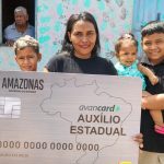 Mulher com cartão do auxílio estadual Amazonas