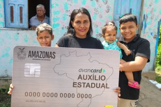 Mulher com cartão do auxílio estadual Amazonas