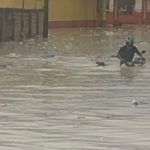 Homem desafia chuva e tenta atravessar área alagada