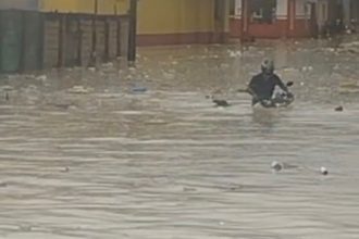Homem desafia chuva e tenta atravessar área alagada