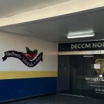 Fachada da delegacia DECCM NORTE/LESTE, com pintura e letreiros indicativos.