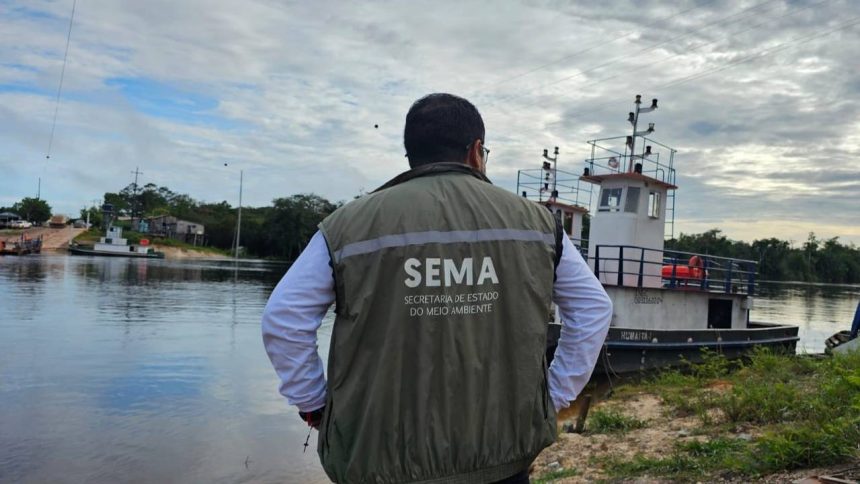 Homem de costas com colete Sema em frente a barco no rio, monitorando o meio ambiente.