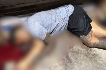 Imagem mostrando pessoas no chão, com manchas de sangue e tatuagens visíveis.