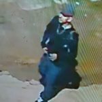 Imagem de segurança mostrando pessoa vestindo roupas escuras e chapéu.