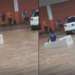 Homem usa geladeira como embarcação durante alagamento em Manaus